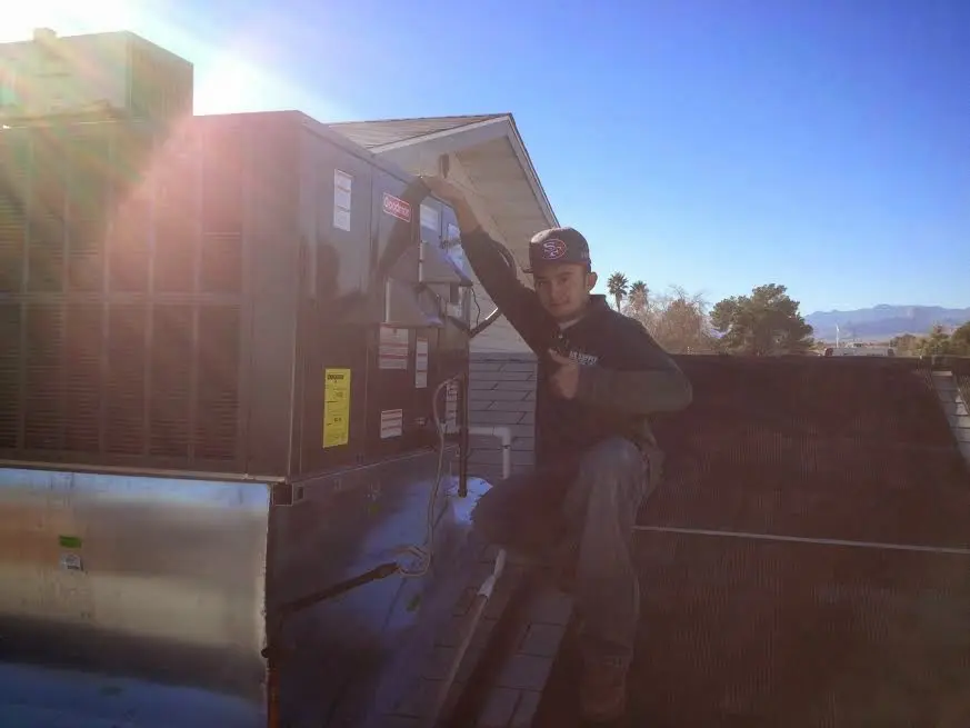 HVAC technician performing AC Tune-Up on a rooftop unit in Doffing